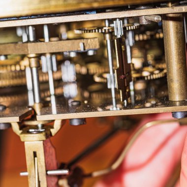 The mechanism of an old watch. clock mechanism made in the technique of toning. Focus on the central gears. Very shallow depth of field