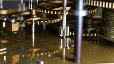 The mechanism of an old watch. clock mechanism made in the technique of toning. Focus on the central gears. Very shallow depth of field