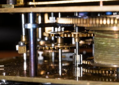 The mechanism of an old watch. clock mechanism made in the technique of toning. Focus on the central gears. Very shallow depth of field