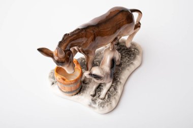 figurine of a donkey that drinks water and next to it a dog teases a donkey