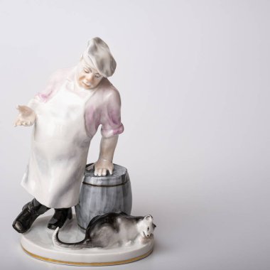 Rare porcelain figurines on a white background. Fat cook and cat eats fish