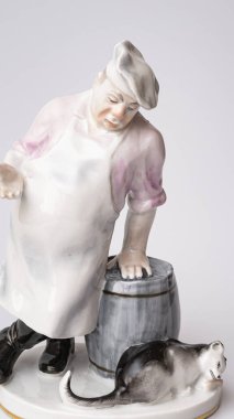 Rare porcelain figurines on a white background. Fat cook and cat eats fish