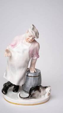 Rare porcelain figurines on a white background. Fat cook and cat eats fish