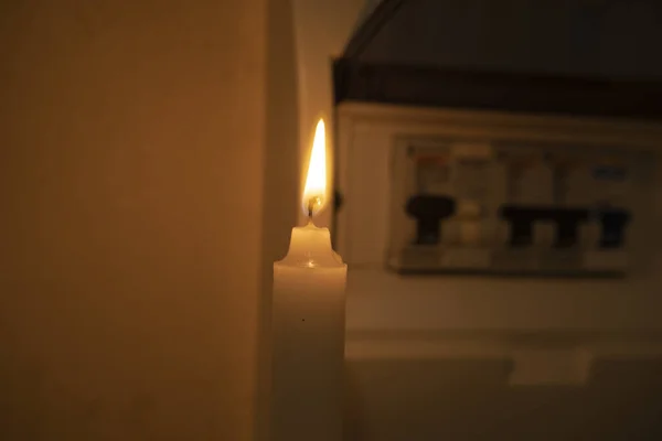 Stock image candle and electrical switches, electricity cut-off, blackout