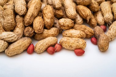 Peanuts in shell isolated on white background. Heap of peanuts close up