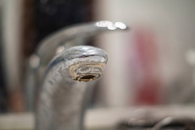 Banyo musluğu eski, kirli, plaka ve pas içinde, kirli su konsepti.