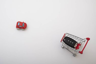 Market arabası ve araba anahtarları, araba satın alma konsepti.