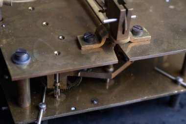 Eski bir saat mekanizması. Tonlama tekniğinde yapılmış bir saat mekanizması. Merkezi dişlilere odaklan. Çok sığ bir alan..