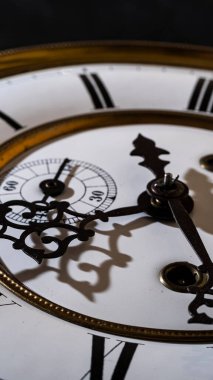 Elleri olan antika bir saat. Altın çerçeveli tarihi bir saatin saat yüzüne yakından bak.