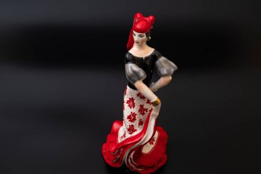 Siyah arka planda kırmızılı porselen çingene figürü. Ev dekorasyonu için geleneksel flamenko dansçısı figürü..