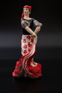 Siyah arka planda kırmızılı porselen çingene figürü. Ev dekorasyonu için geleneksel flamenko dansçısı figürü..