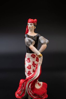 Siyah arka planda kırmızılı porselen çingene figürü. Ev dekorasyonu için geleneksel flamenko dansçısı figürü..