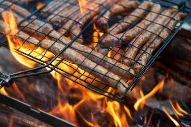 Bahçede mangal partisi. Izgarada ızgara sosis. Bavyera sosisi. Barbekü pişirme. Açık ateşte yemek pişirmek.