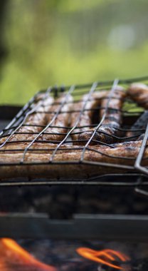 Bahçede mangal partisi. Izgarada ızgara sosis. Bavyera sosisi. Barbekü pişirme. Açık ateşte yemek pişirmek.