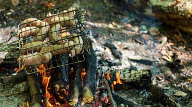Bahçede mangal partisi. Izgarada ızgara sosis. Bavyera sosisi. Barbekü pişirme. Açık ateşte yemek pişirmek.