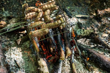 Bahçede mangal partisi. Izgarada ızgara sosis. Bavyera sosisi. Barbekü pişirme. Açık ateşte yemek pişirmek.