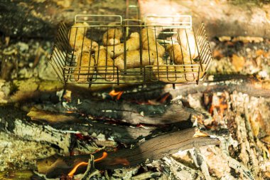 Bahçede mangal partisi. Izgarada ızgara sosis. Bavyera sosisi. Barbekü pişirme. Açık ateşte yemek pişirmek.