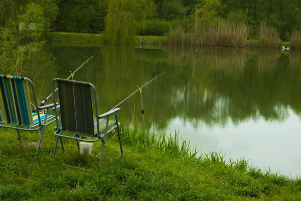 夜明けに湖の上の背景に漁師の椅子と釣竿 釣りの概念 美しい日の出 朝の風景です 霧の中に釣竿を持つ漁師の場所 — ストック写真