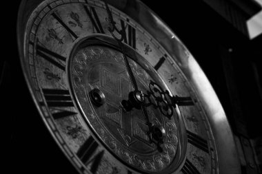 Old wooden clock with a pendulum hanging on the wall