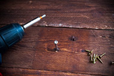 Tornavidayla vidayı sıkmak. Marangoz, ahşap mobilyalı kablosuz tornavida kullanıyor. Marangoz ahşap mobilyaları tornavidayla birleştirir..
