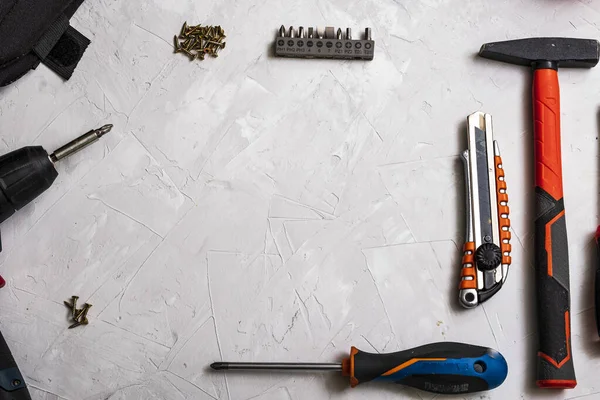 stock image Top view of working tools, hammer, screwdriver, pliers, electric drill, tape measure, screws on a white background.