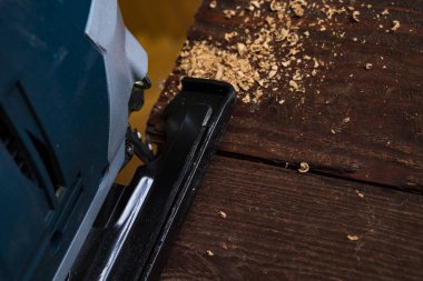 Elektrikli yapboz ve tahtayla çalışan marangoz. Plank kesme konsepti