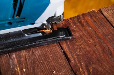 Elektrikli yapboz ve tahtayla çalışan marangoz. Plank kesme konsepti