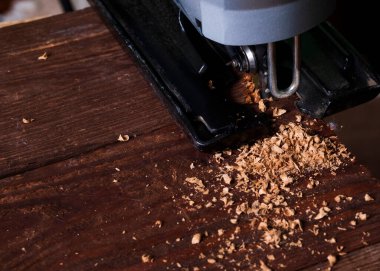 Elektrikli yapboz ve tahtayla çalışan marangoz. Plank kesme konsepti