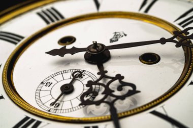 Elleri olan antika bir saat. Altın çerçeveli tarihi bir saatin saat yüzüne yakından bak.