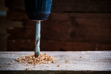 Ahşap arka planda basamaklı koni matkabı.