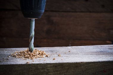 Ahşap arka planda basamaklı koni matkabı.