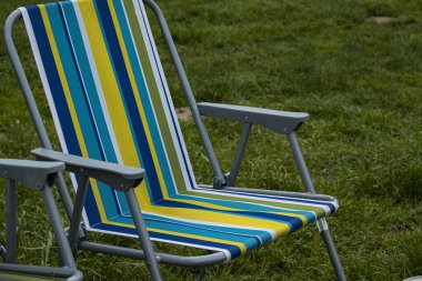 Balıkçı oltası, nehir kıyısındaki iskelenin arka planında dönen makara. Gün doğumu. Vahşi doğa. Kırsal tatil konsepti. Balık tutma günü hakkında bir makale..