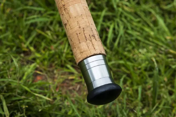 Balıkçı oltası, nehir kıyısındaki iskelenin arka planında dönen makara. Gün doğumu. Vahşi doğa. Kırsal tatil konsepti. Balık tutma günü hakkında bir makale..