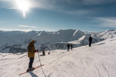Alp karlı tepelerde kayak yapan kayakçılar ve snowboardcular
