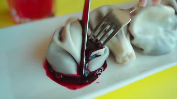 フォークとナイフで女性の手を切った団子ジューシーなブルーベリーのもの レストランでのオリジナルのデザート — ストック動画