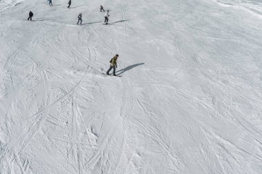 Alp karlı tepelerde kayak yapan kayakçılar ve snowboardcular