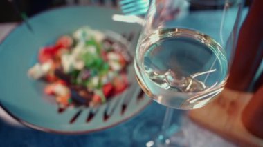 Gürcü restoranında nefis bir akşam yemeği, sağlıklı sebze salatası, beyaz peynir tabakta balzamik sos ve kadehte şarap.