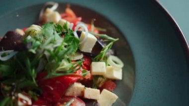 Taze sebze salatası, beyaz peynir ve siyah tabakta balzamik sos, sağlıklı yemek.