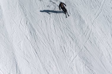 Güneşli kış gününde Alp karlı tepelerde kayak yapan kayakçılar