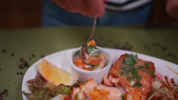 Comer Pescado Parrilla Sumergir Salmón Horno Salsa Con Perejil Restaurante — Vídeo de stock
