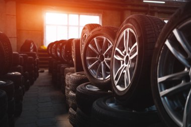auto repair service center or tire store with new car wheels prepared for vehicles, change tyre concept 