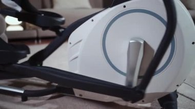 Spor kulübündeki eliptik yörünge makinesi üzerinde egzersiz yapan yakın plan kadın ayakları
