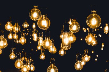 Karanlık odada tavana asılmış eski el işi ampuller.