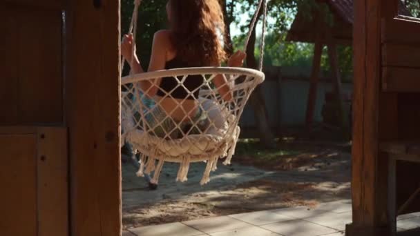 Achteraanzicht Van Meisje Zitten Swingen Opknoping Gebreide Hangmat Stoel Boheemse — Stockvideo