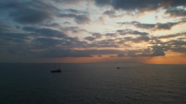 Gün batımında açık denizde ya da okyanusta iki sürat teknesi, hava manzaralı. Yüksek kalite 4k görüntü