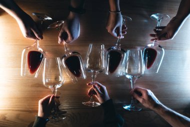 İnsanlar kafe veya barda kutlama yapıyor ve lüks kırmızı ve beyaz şarap içiyor, tahta arka plan düz konsept, üst görünüm