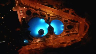 Okyanus kıyısı ve ışıkları, mavi yüzme havuzu, oteller ve tatil köyleri, Tenerife, Kanarya adası olan aydınlık şehir veya kasabanın hava aracı manzarası. Yüksek kaliteli hava üst görünümü 4k görüntü