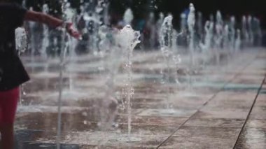 Neşeli çocuklar oynuyor, zıplıyor ve çeşme suyu püskürtüyor. Yüksek kaliteli FullHD görüntüler, yavaş çekim