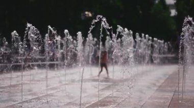 Neşeli çocuklar oynuyor, zıplıyor ve çeşme suyu püskürtüyor. Yüksek kaliteli FullHD görüntüler, yavaş çekim
