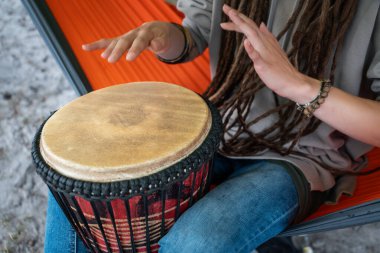Rastalı kişi küçük Afrika el davulu djembe 'sinde kabile reggae çalıyor. Yüksek kaliteli resim